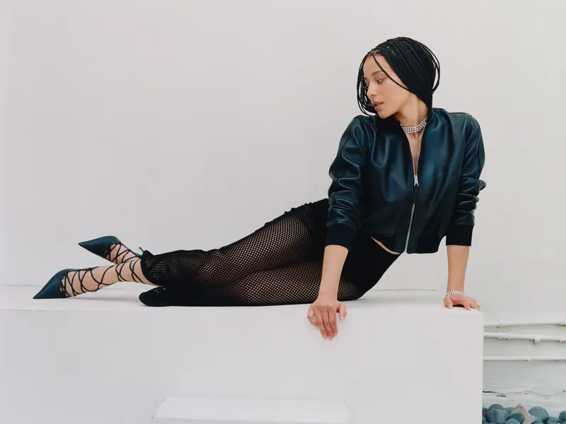 Portrait in a leather bomber jacket, seated on a ledge